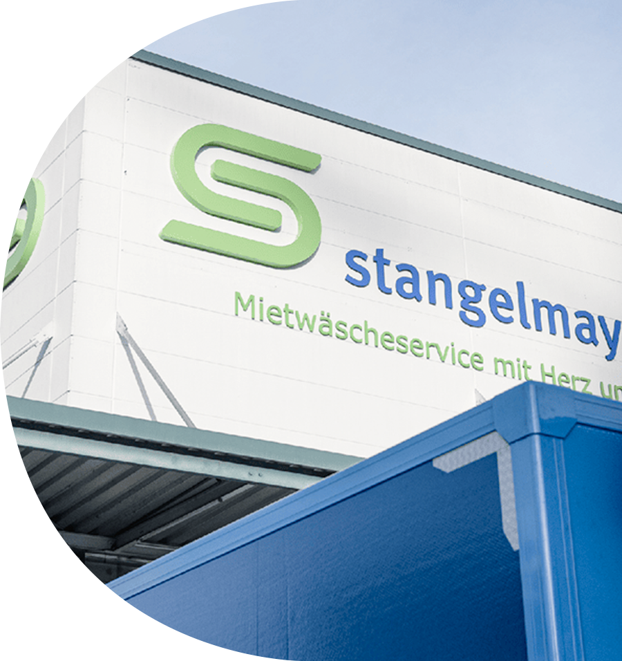 Textilservice Stangelmayer Ansicht des Logos am Gebäude - für moderne Karriereseite, die authentische Einblicke in Kultur und Entwicklungsmöglichkeiten gibt