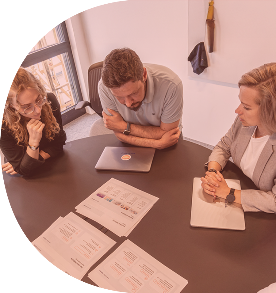 Team von twentyfourtalents im Strategie-Workshop am runden Tisch bei der Analyse von Recruiting-Unterlagen – Employer Branding Beratung in Rosenheim